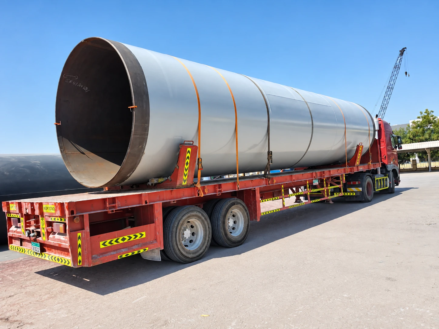 A large coated pipe section on an 18 metre ADSO flatbed trailer